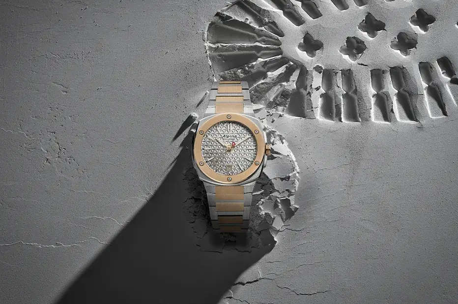 Zegarek damski Alpina Alpiner Extreme Quartz AL-220S2AE2B z dwukolorową bransoletą na tle odcisku trekkingowego buta
