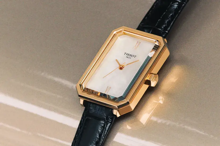 Zegarek damski Tissot SRV T160.110.36.113.00 z prostokątną kopertą w kolorze różowego złota i tarczą z naturalnej masy perłowej na czarnym skórzanym pasku