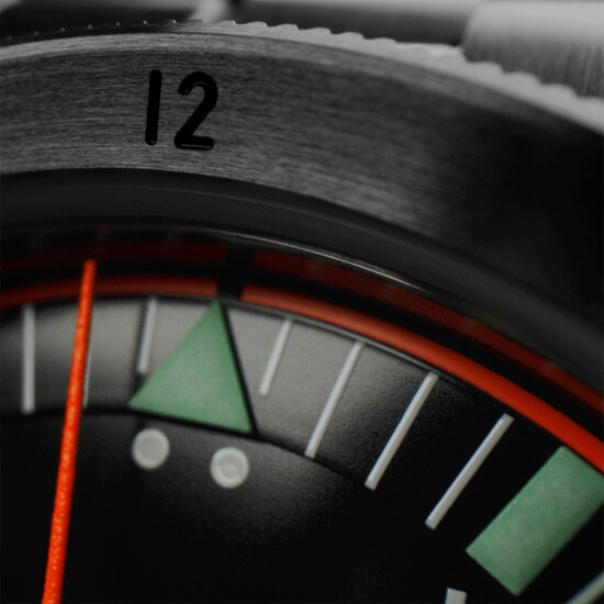 Charakterystyczny trójkąt przy godzinie 12 i 2 podświetlane kropki.