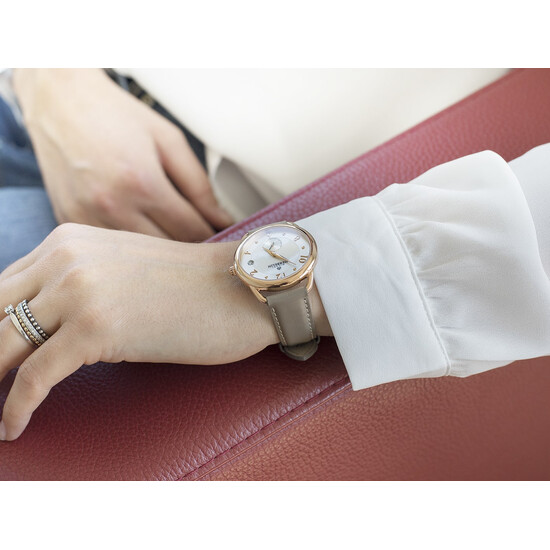 Pozłacany zegarek Equinoxe na damskim nadgarstku.